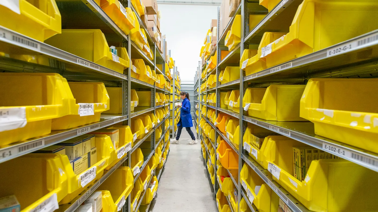 A warehouse aisle of yellow stock bins