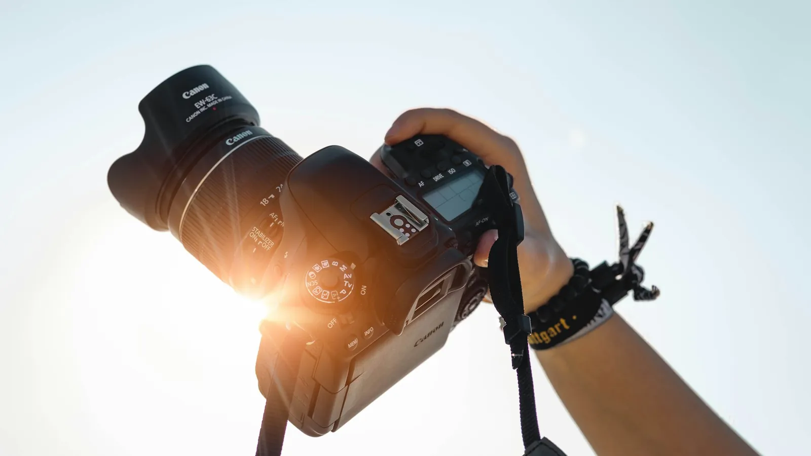 A camera held up against a bright sky