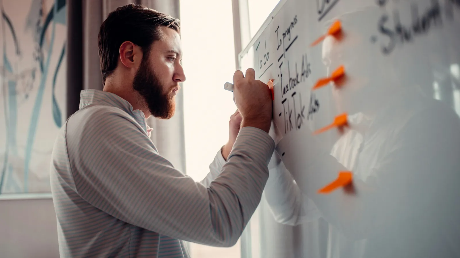 A man mapping out a plan on a whiteboard