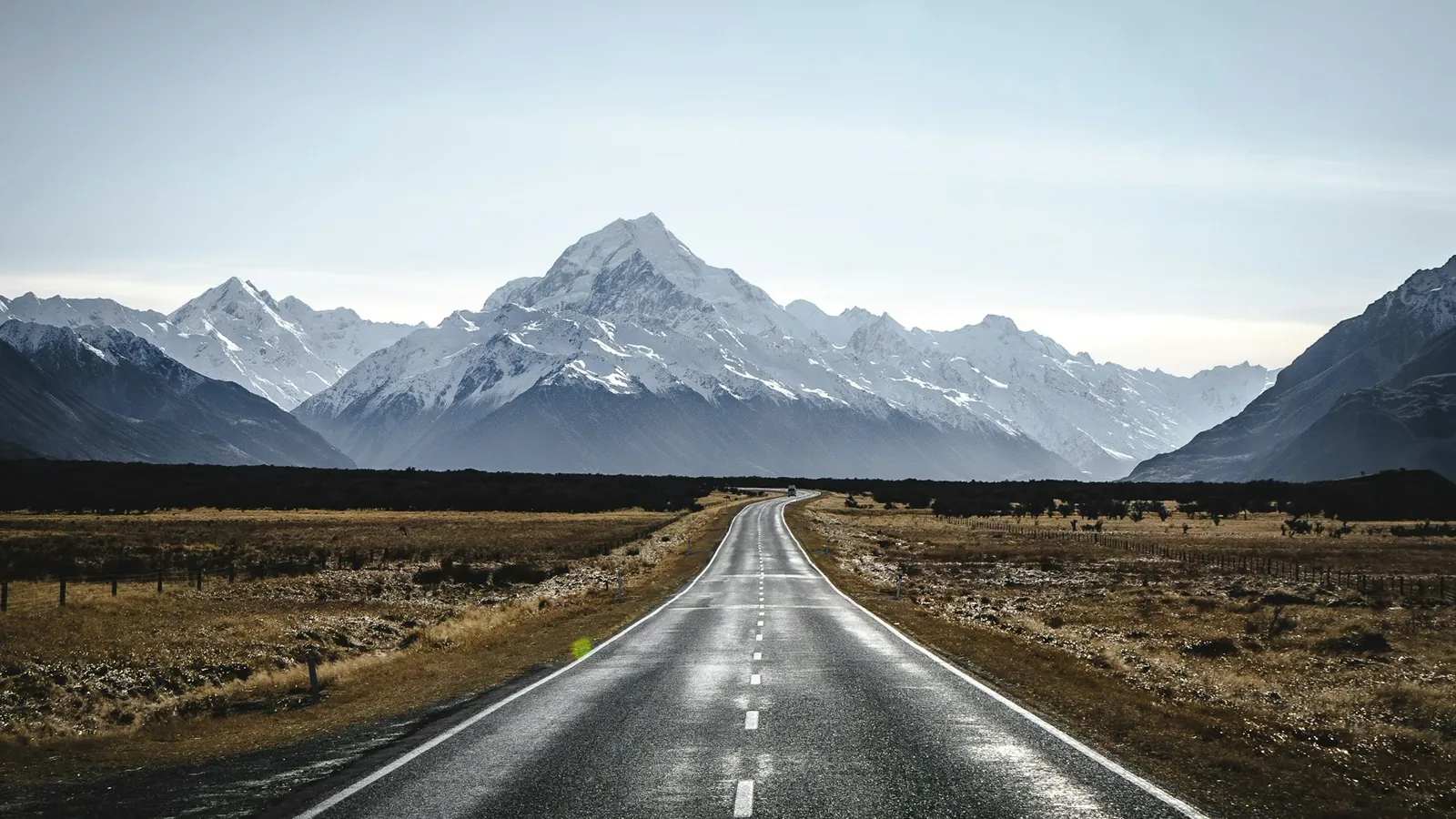 A straight rural road towards snowy mountains, New Zealand