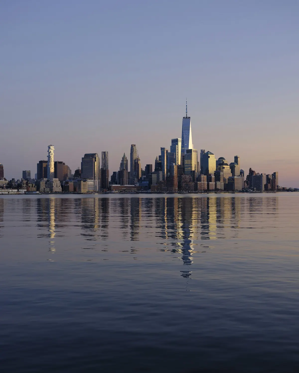 A city skyline across the water at dusk
