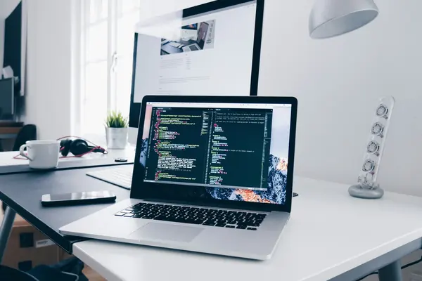 Laptop on a desk showing website code